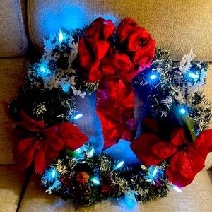 Battery operated Christmas wreath. Red poinsettias w/red bow/white lights